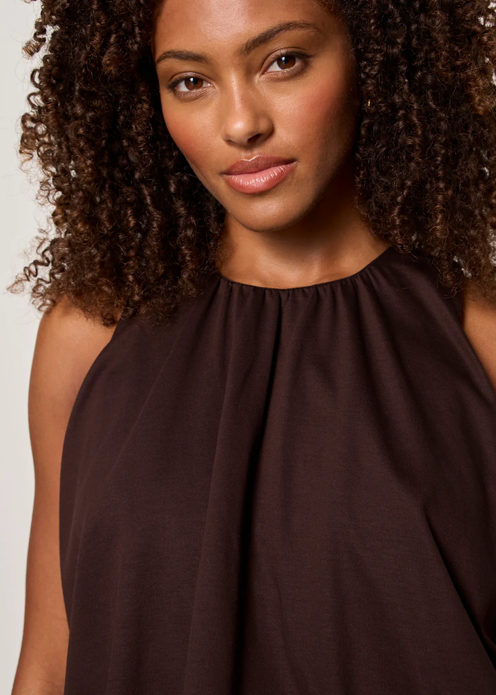 Close up of a woman wearing a brown tank top with matching pants