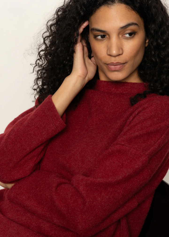 Close up of a woman wearing a crimson red sweater