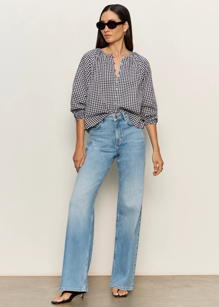Woman wearing a black and white gingham top with jeans