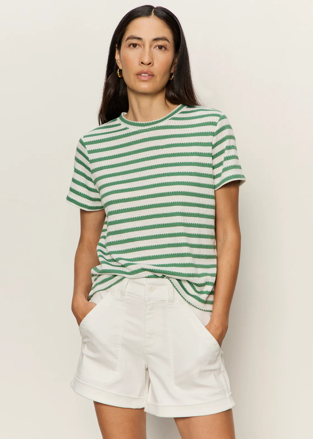 Woman wearing a green and white striped t-shirt with white shorts