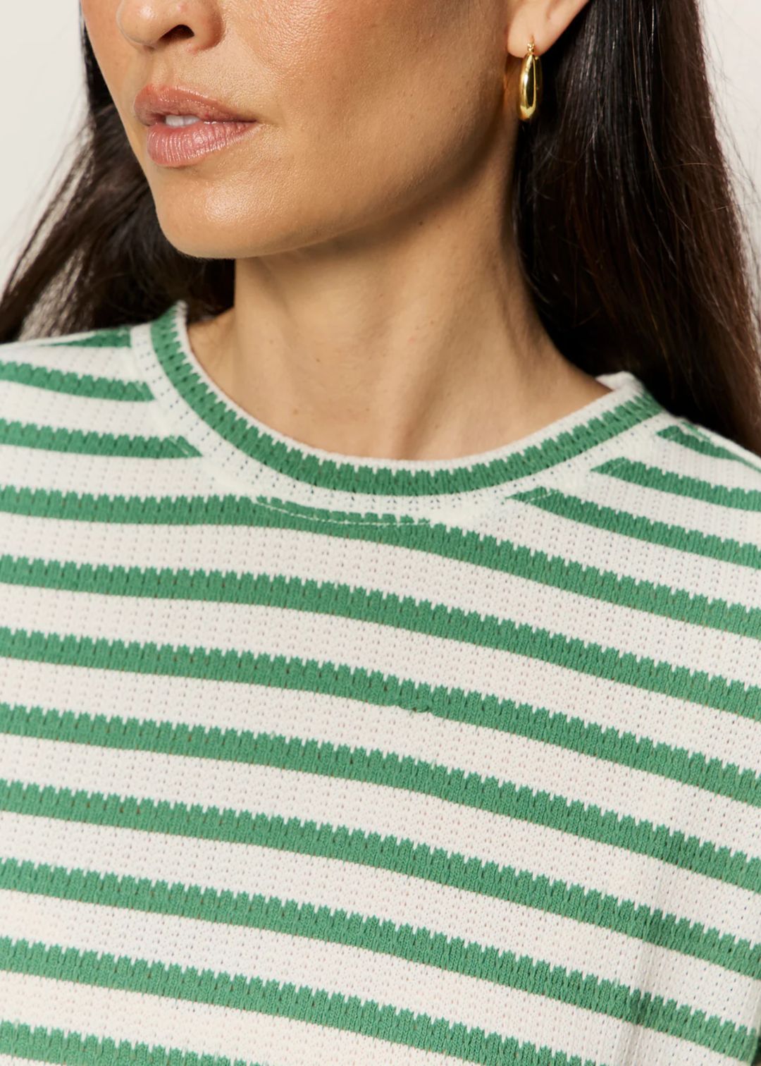 Close up of a woman wearing a green and white striped t-shirt
