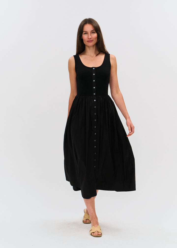 Woman wearing a black midi dress with tan sandals