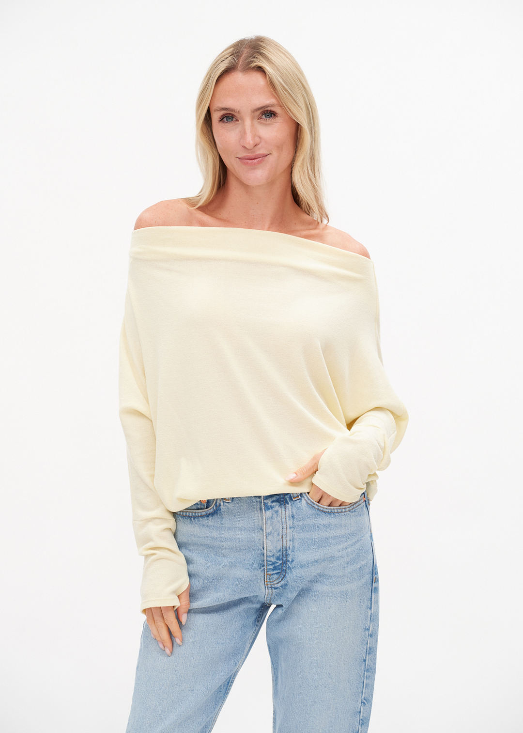 Woman wearing an off the shoulder yellow top with jeans
