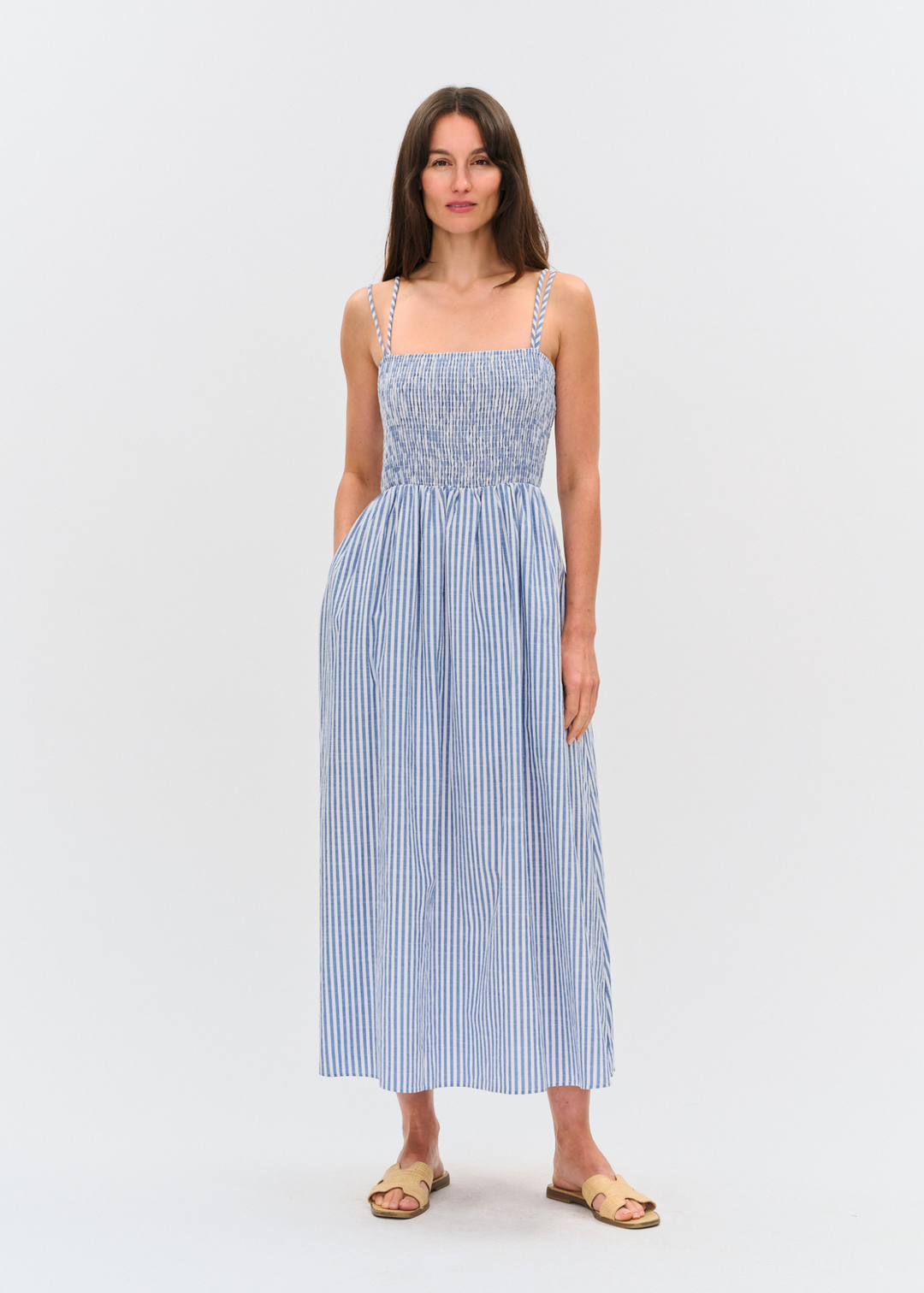 Woman wearing a blue and white striped maxi dress with sandals
