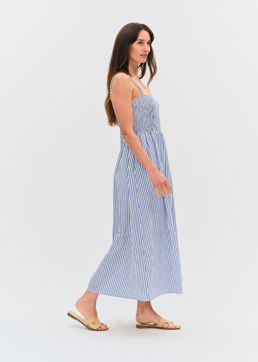 Woman wearing a blue and white striped maxi dress with sandals