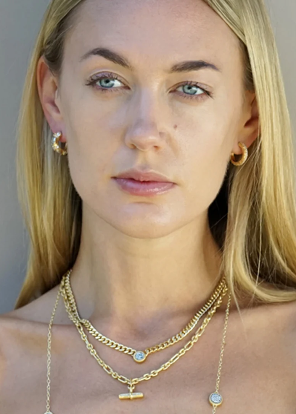 Woman wearing multiple gold layered necklaces