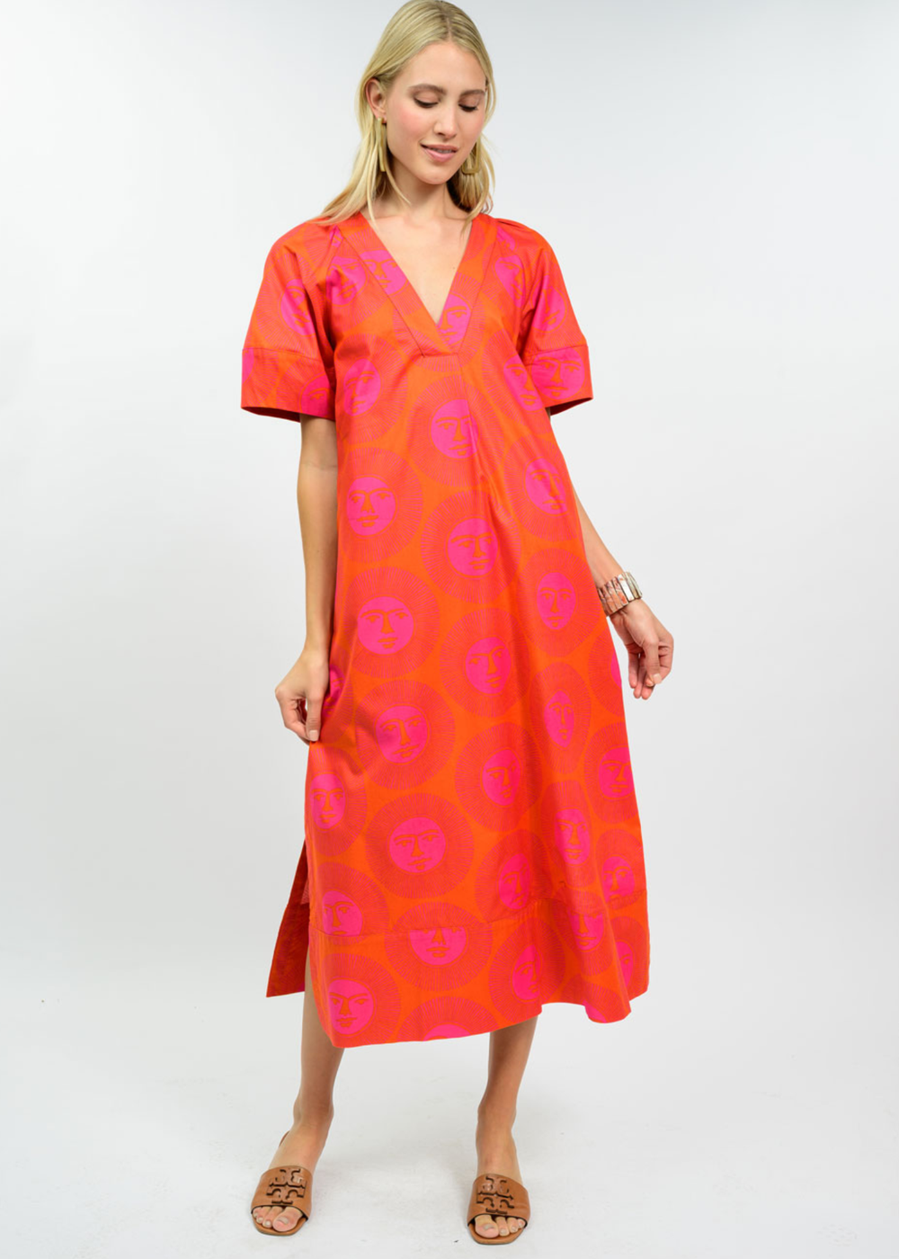 Woman wearing a hot pink and orange midi dress with sandals