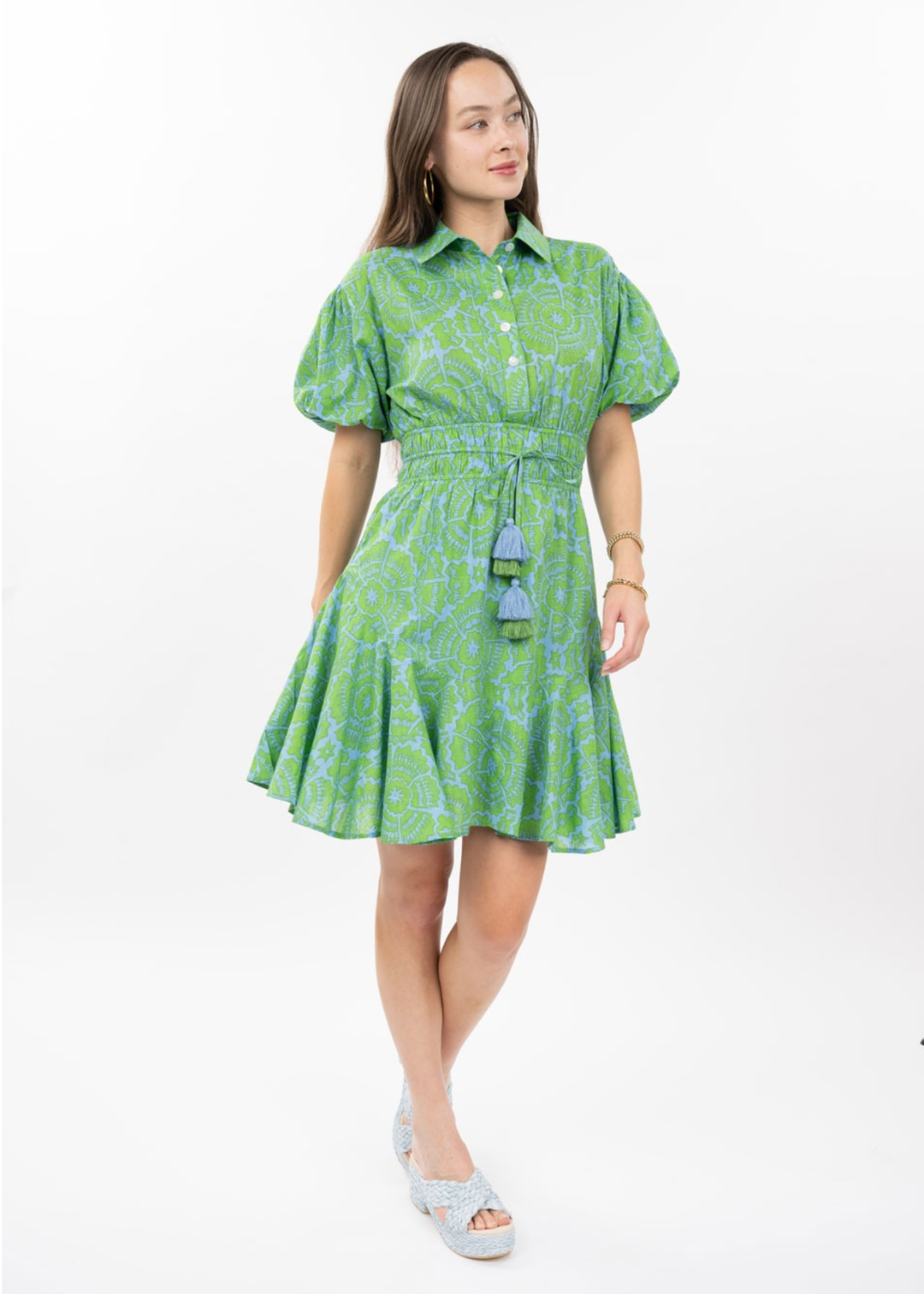 Woman wearing a green floral mini dress with puff sleeves