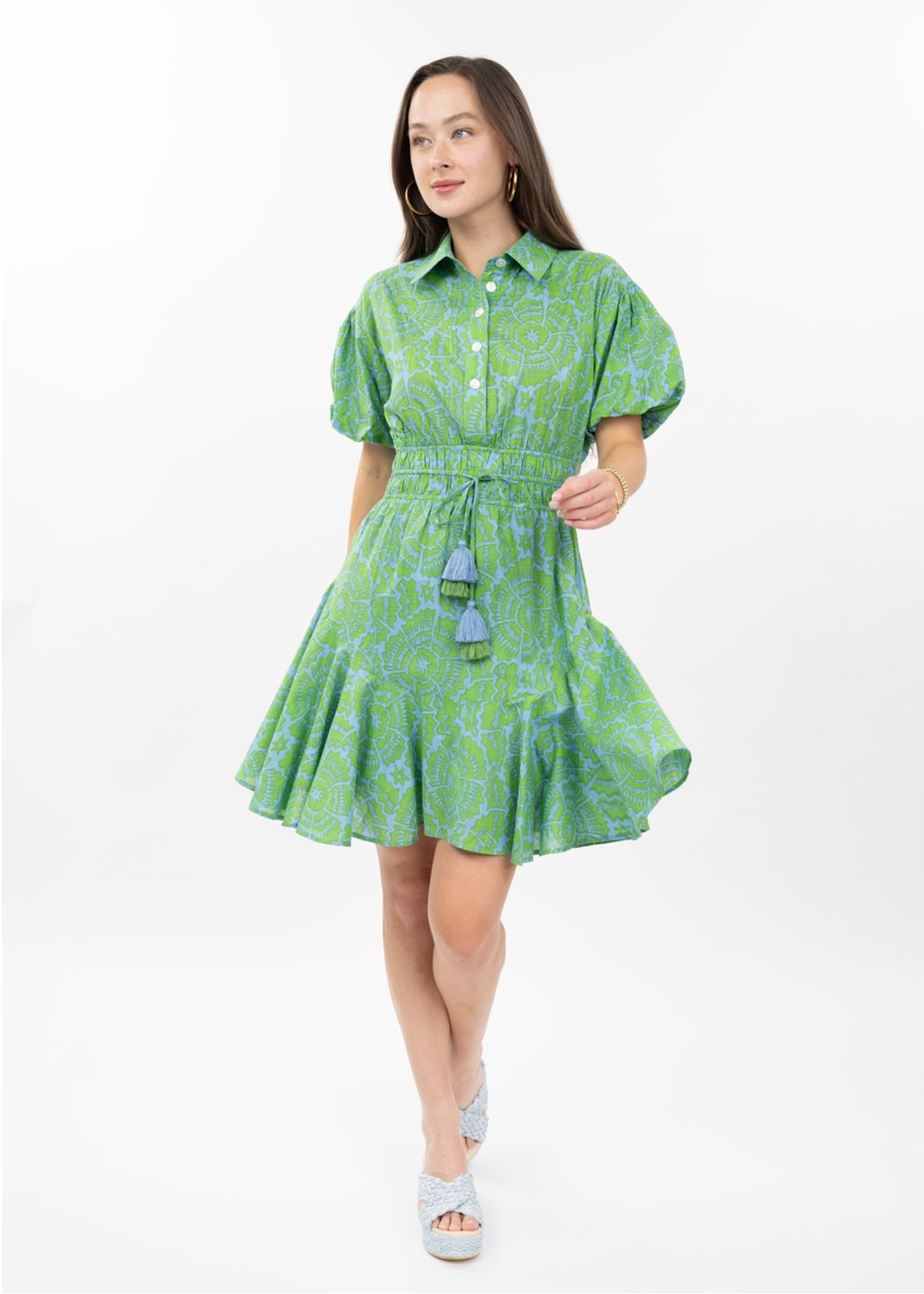 Woman wearing a green floral mini dress with puff sleeves