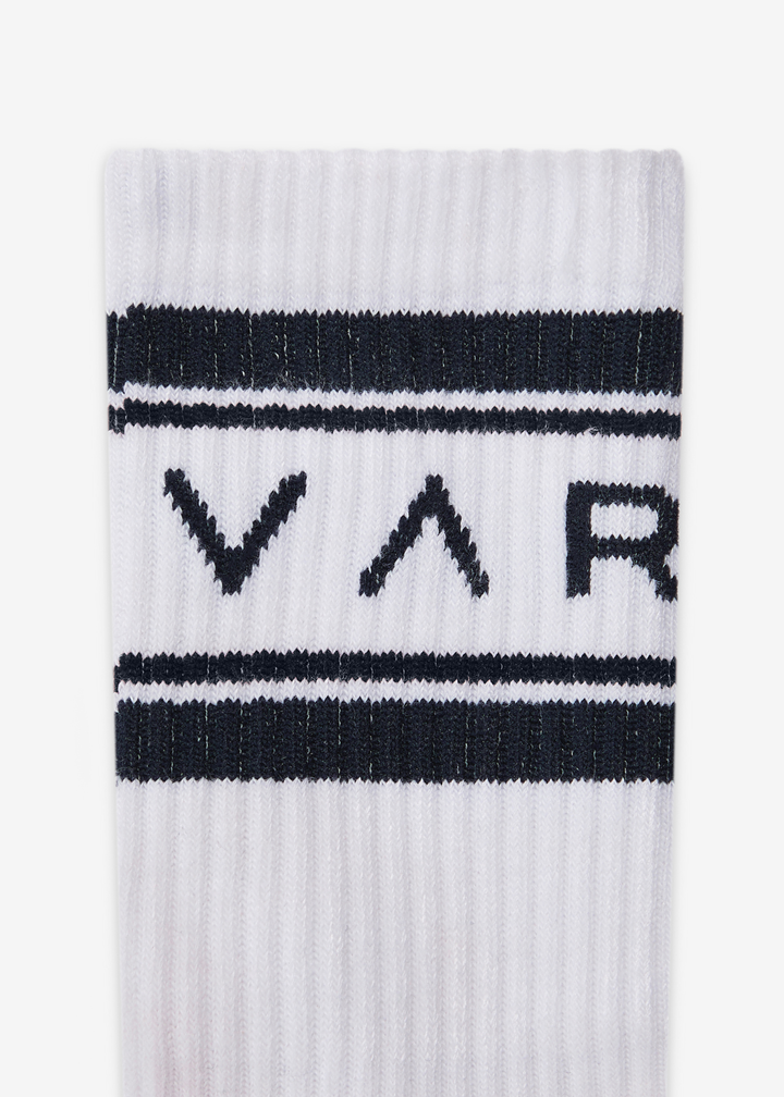 Close up of white crew socks with navy stripes and navy "VAR" lettering against a white background