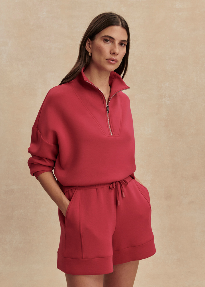 Woman wearing pink shorts and a matching sweatshirt