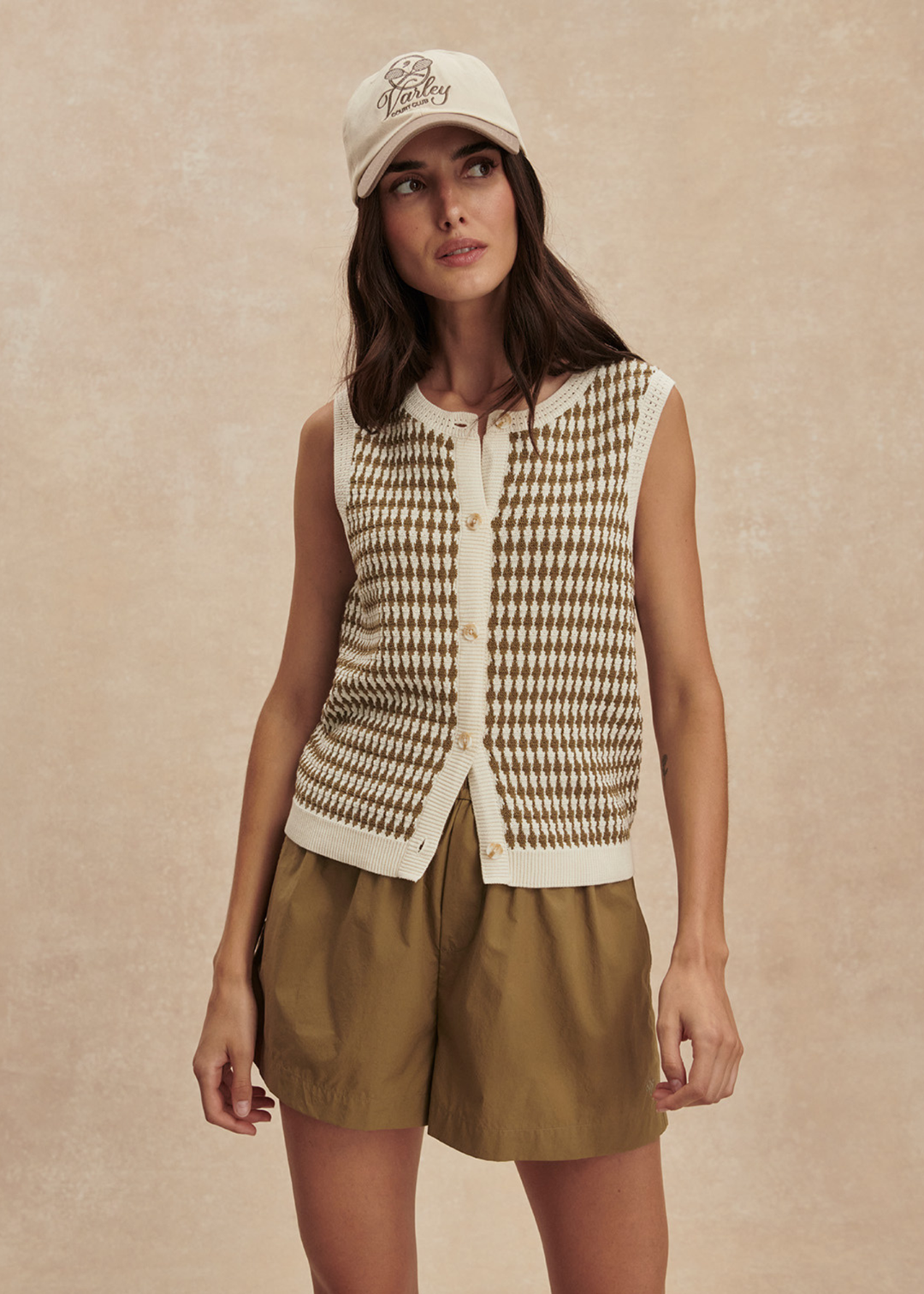 Woman wearing a brown and white knit button up tank top with matching brown shorts