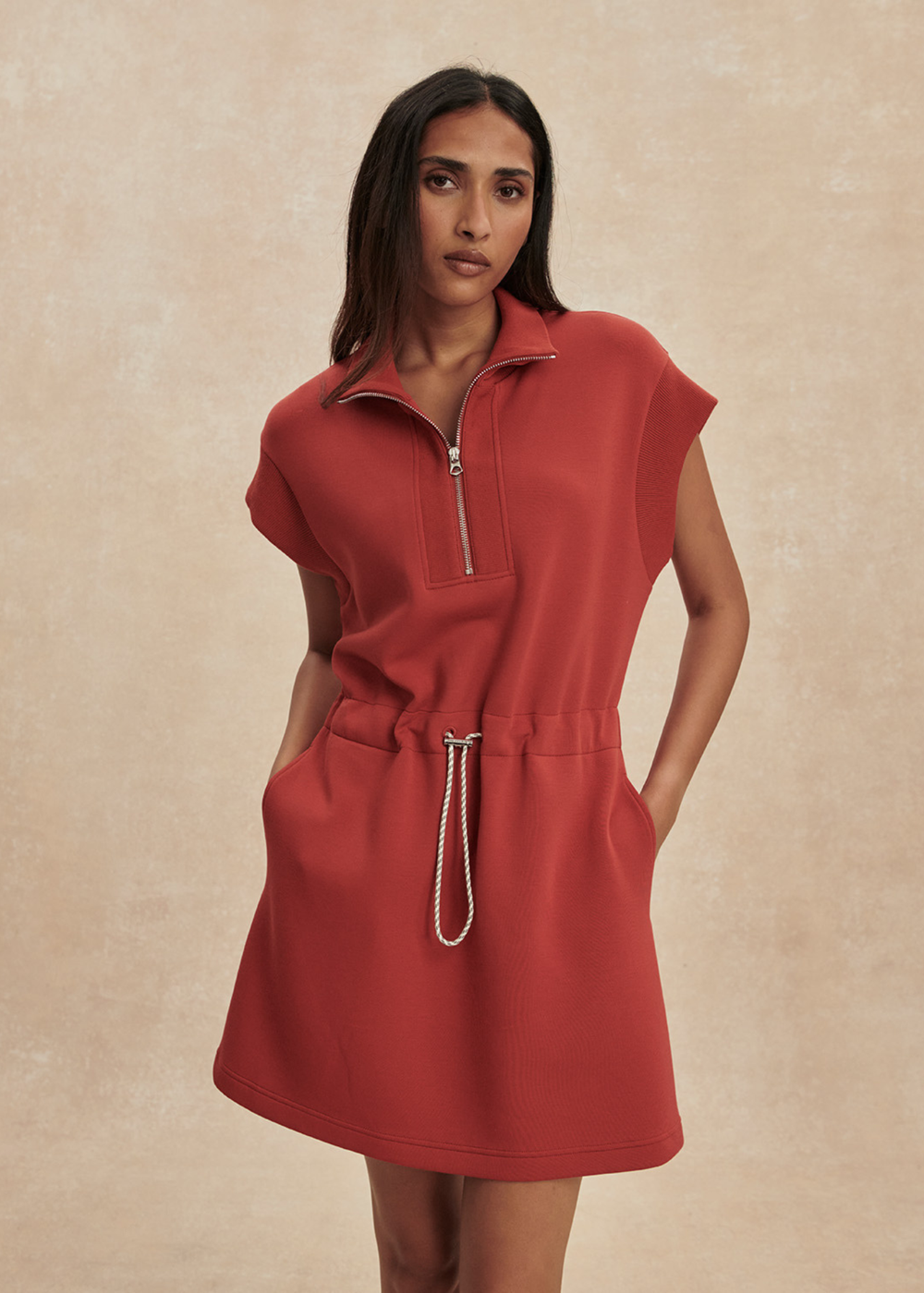 Woman wearing a red/orange half zip mini dress