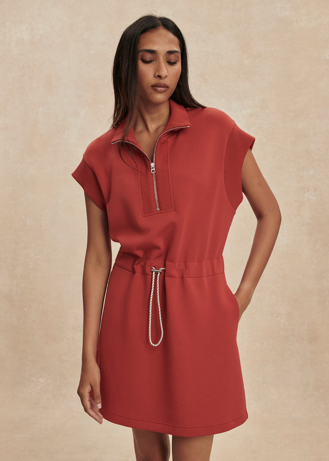 Woman wearing a red/orange half zip mini dress