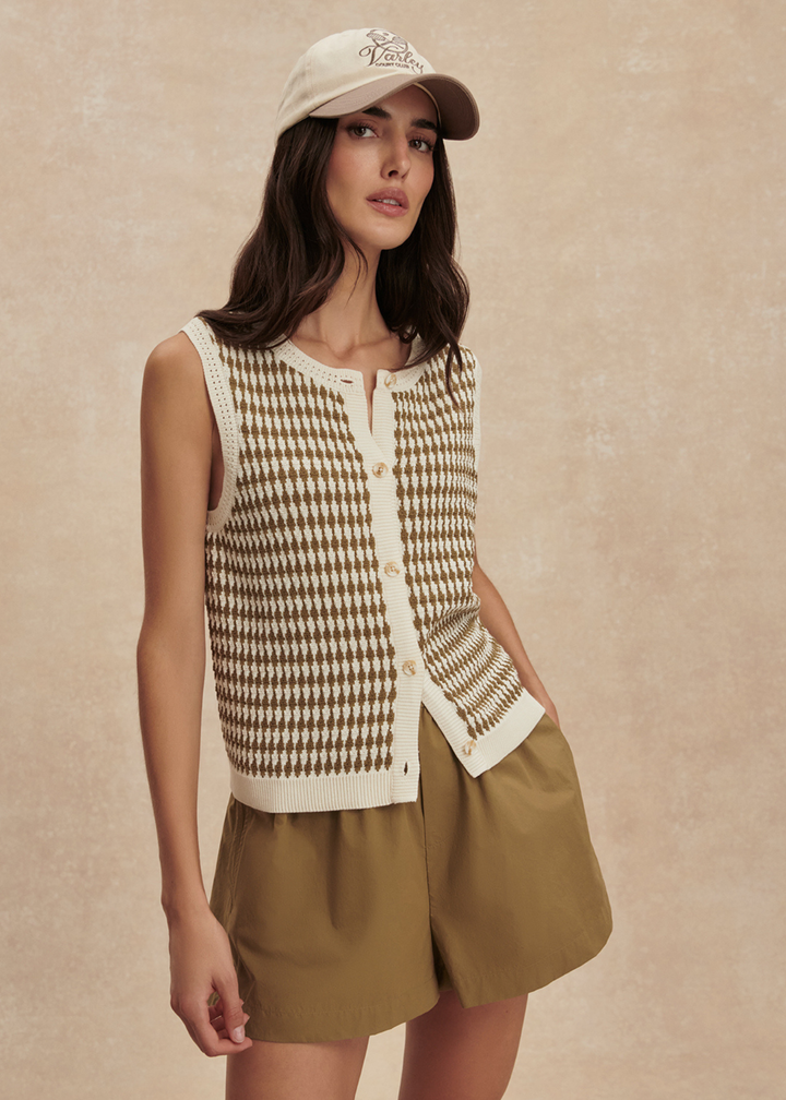 Woman wearing a gold and white knit tank with matching gold shorts