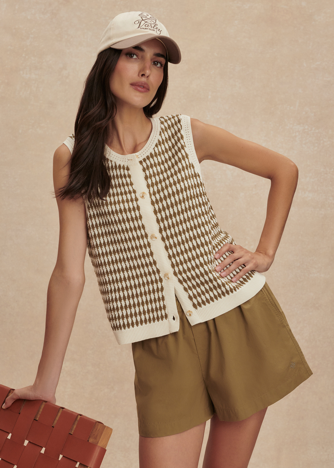 Woman wearing a gold and white knit tank with matching gold shorts