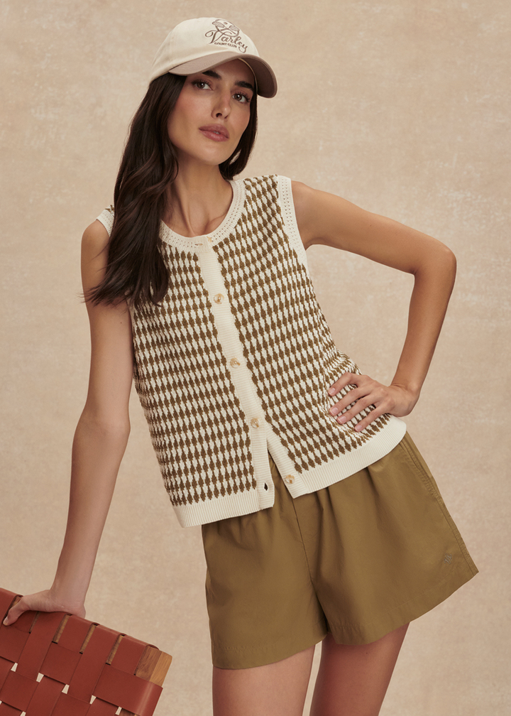 Woman wearing a gold and white knit tank with matching gold shorts