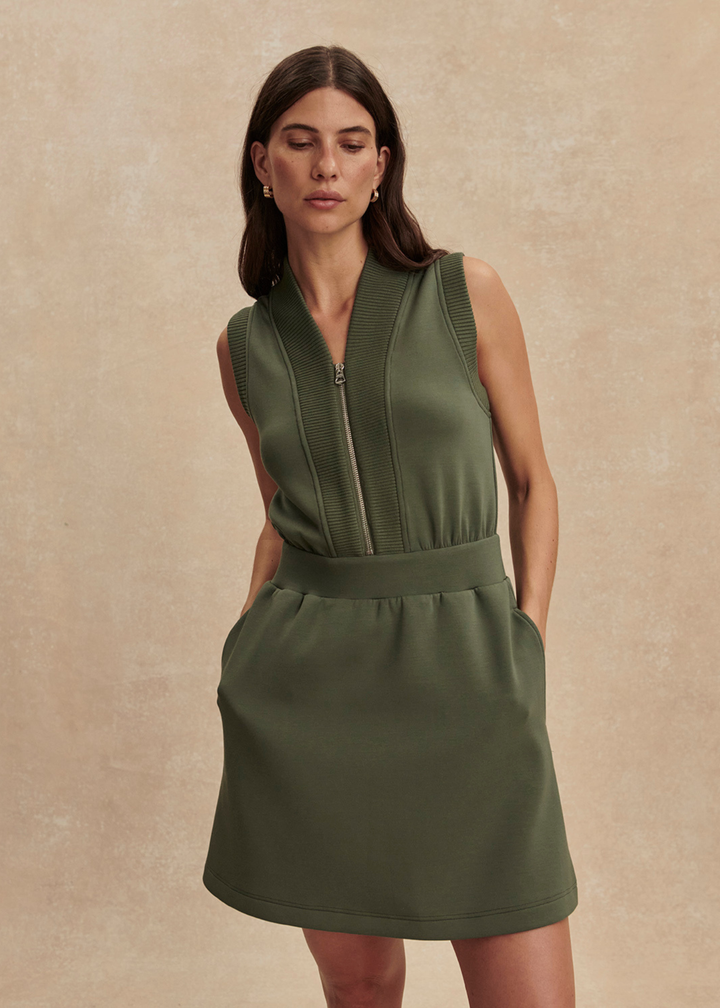 Woman wearing a green half zip mini dress with sandals