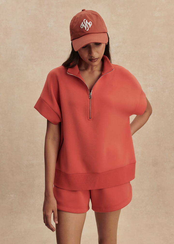Woman wearing an orange top with matching shorts
