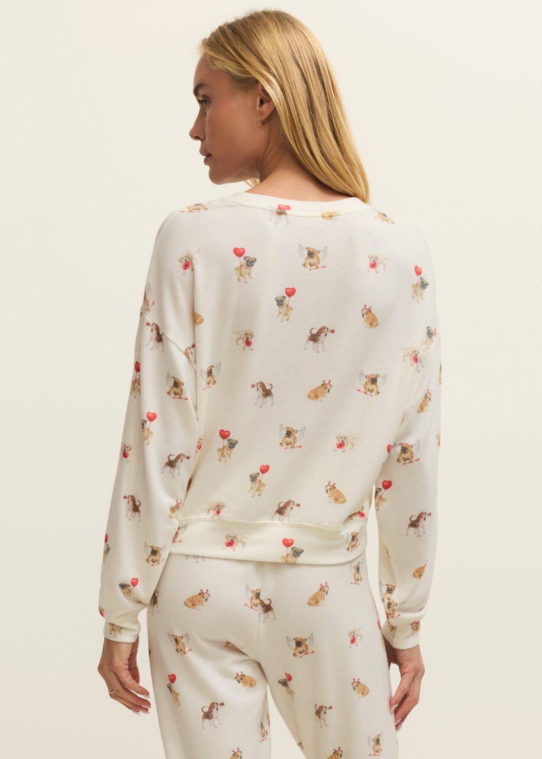 Woman turned around wearing white pajamas with a graphic dog pattern