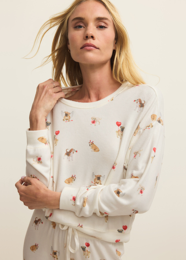Woman with arms crossed wearing white pajamas with a graphic dog pattern