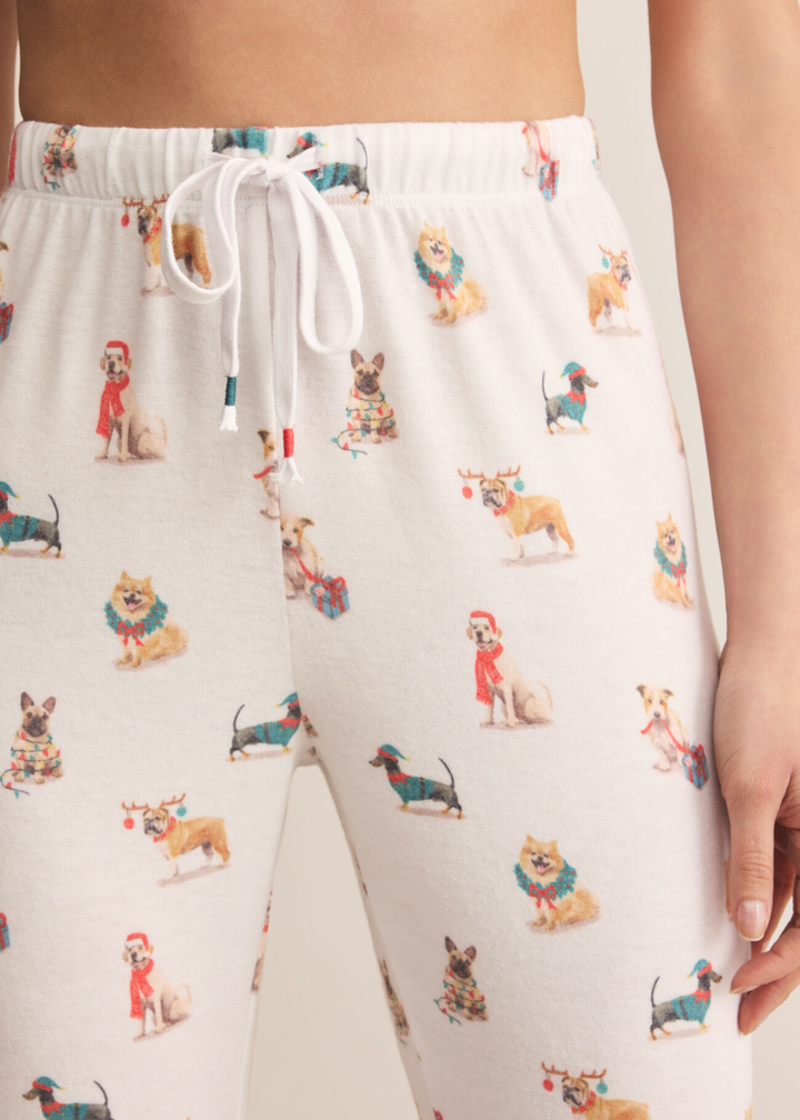 Close up of a woman wearing white joggers with a Christmas dog pattern