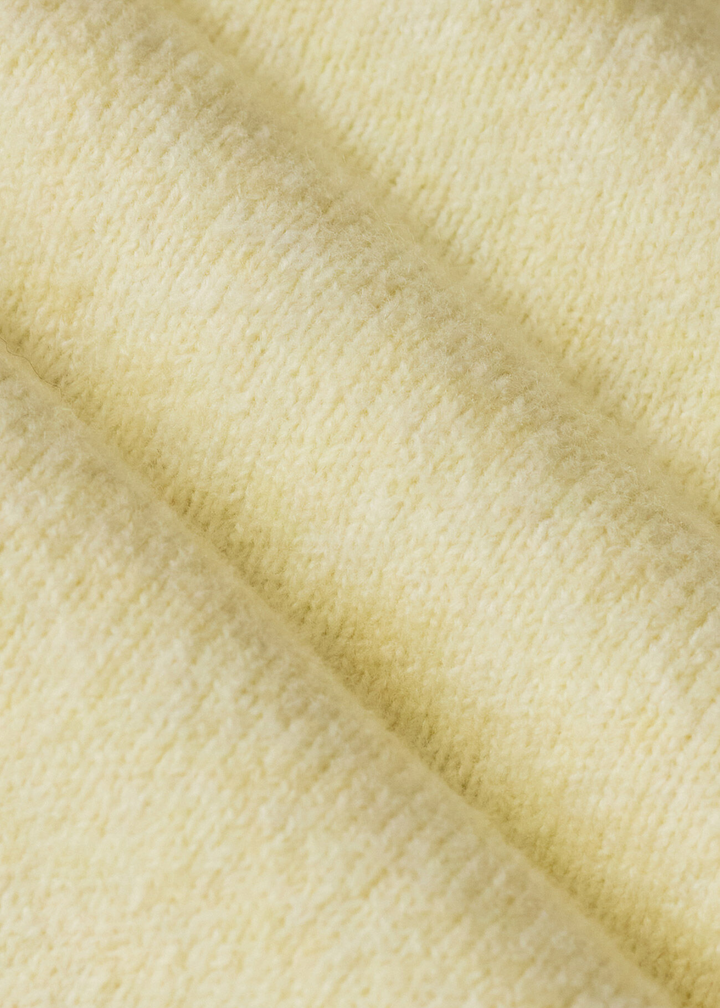 Close up of the fabric of a yellow sweater