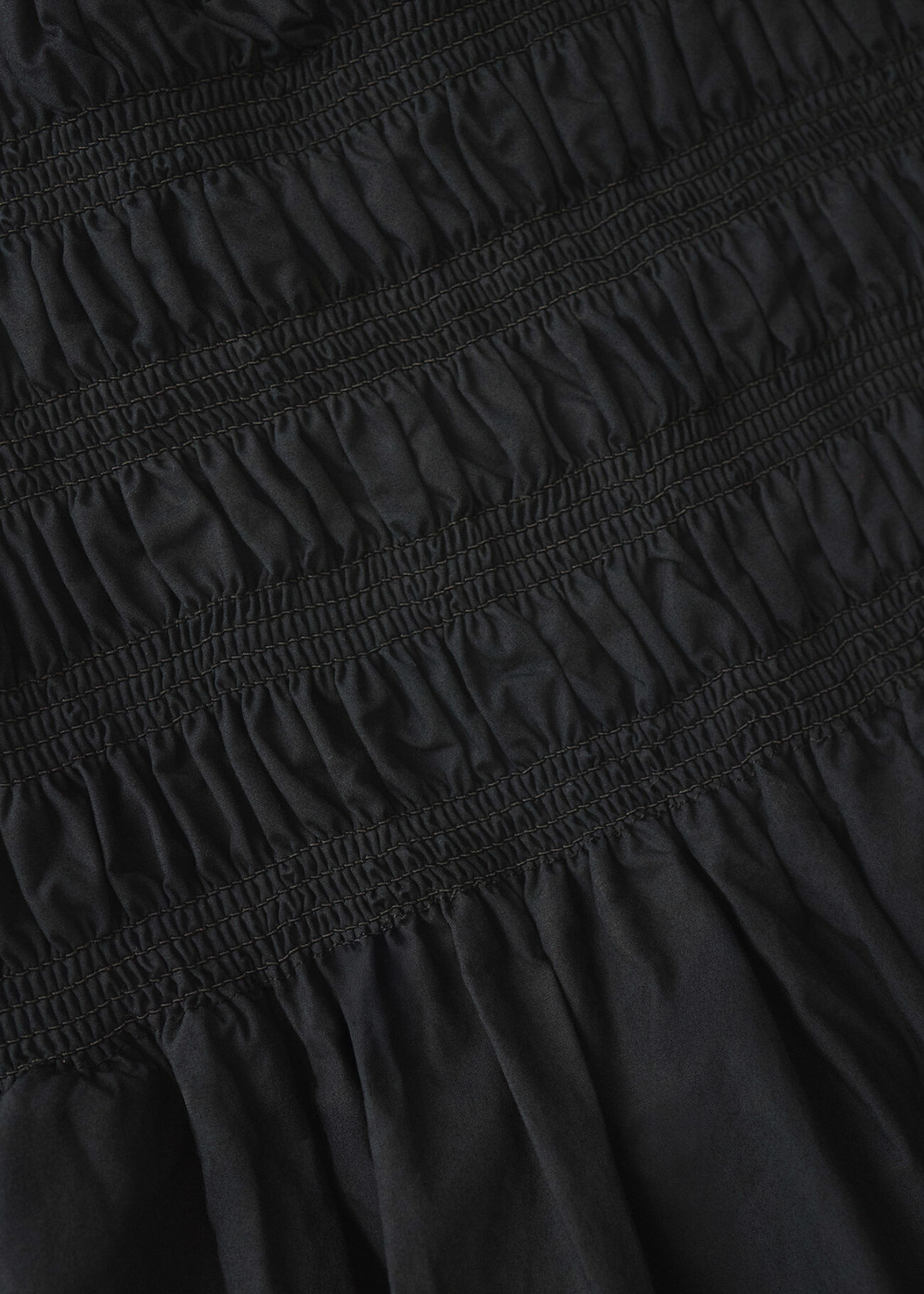 Close up of a black dress with ruched fabric