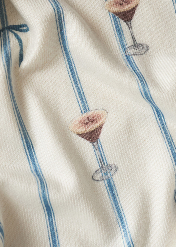 Close up of fabric with a blue ribbon and espresso martini pattern