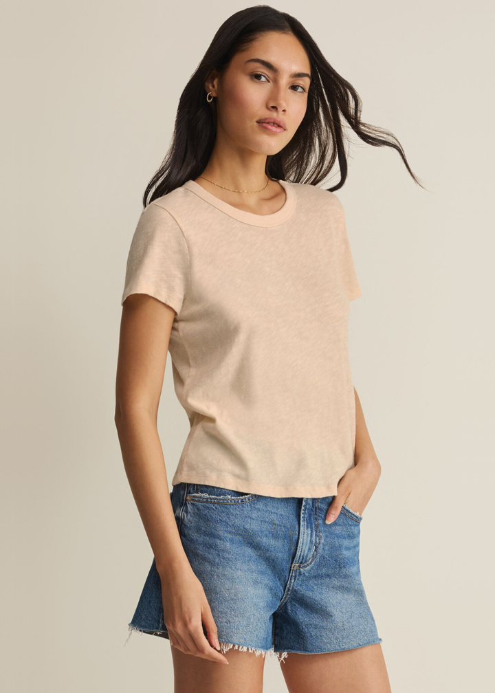Woman wearing a tan t-shirt with denim shorts