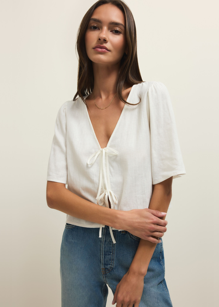 Woman wearing a short sleeve white linen tie front top with jeans