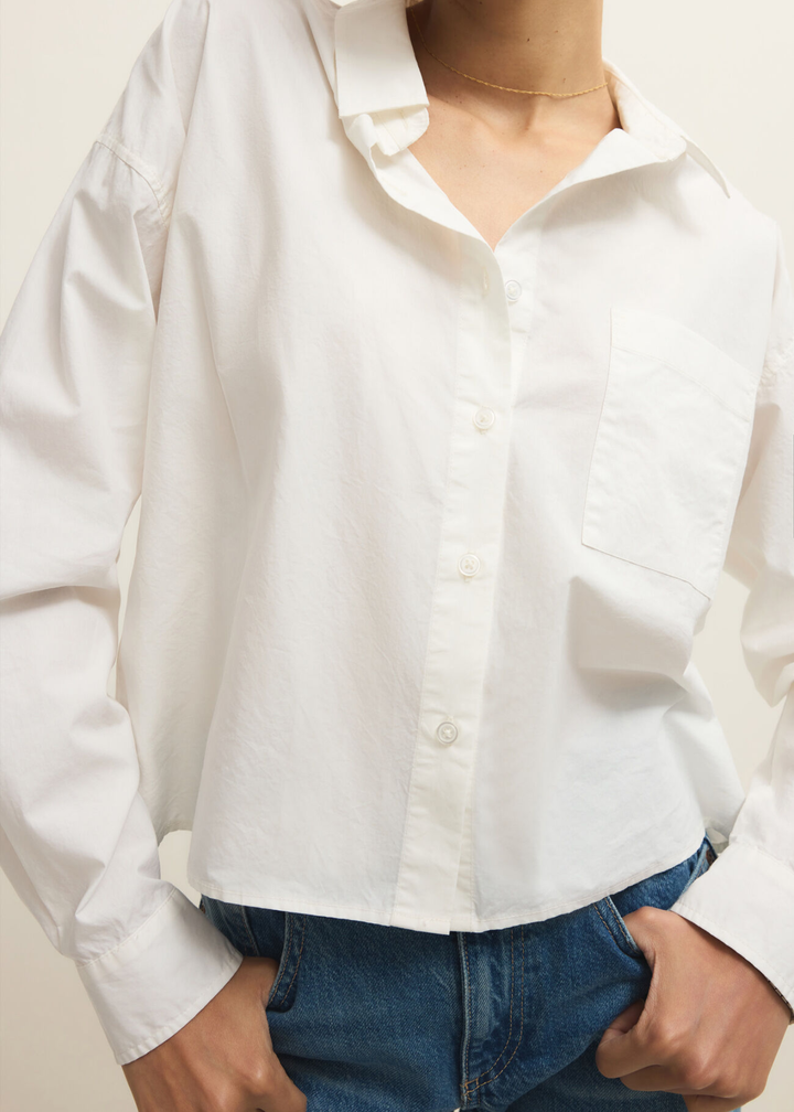 Woman wearing a white button down top with jeans