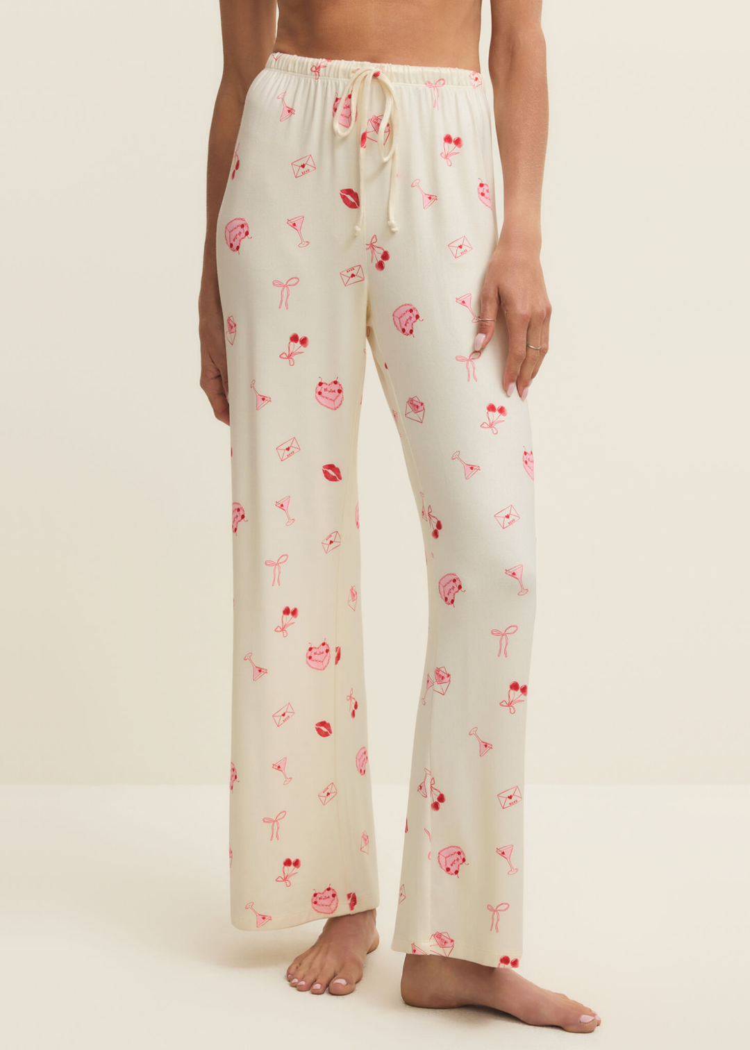 Woman wearing white pajama pants with a pink and red graphic pattern