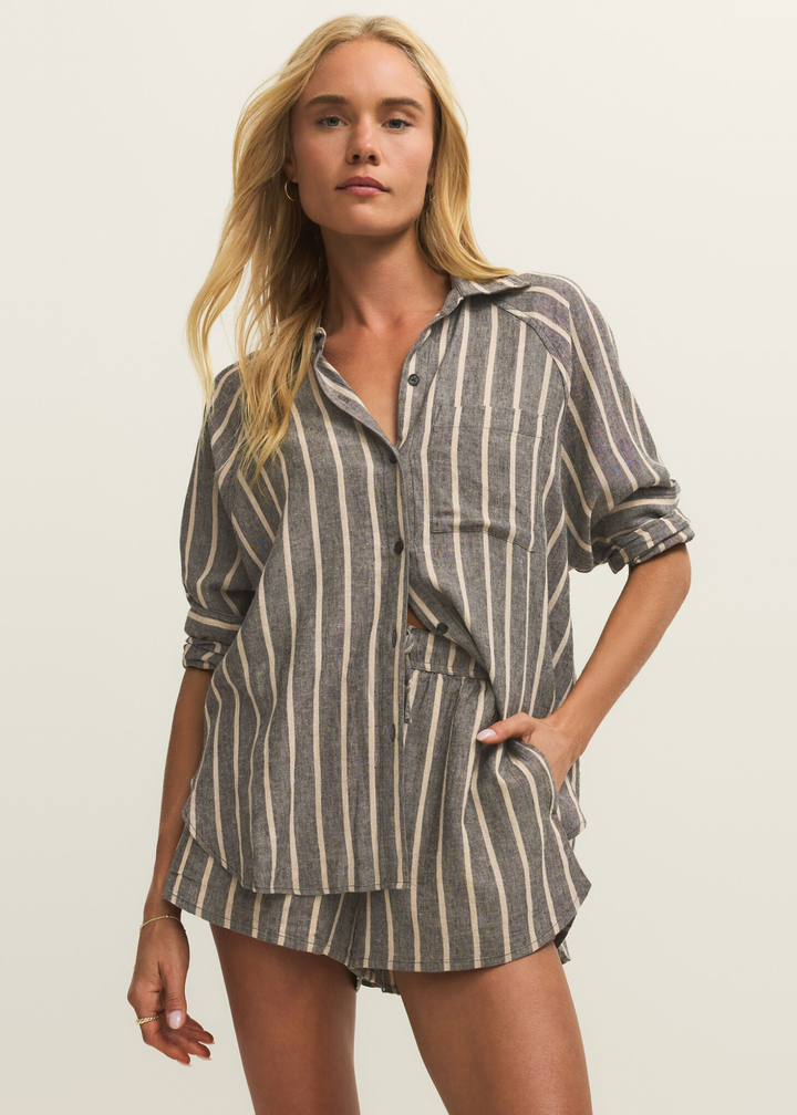 Woman wearing a black button down with white stripes and matching shorts