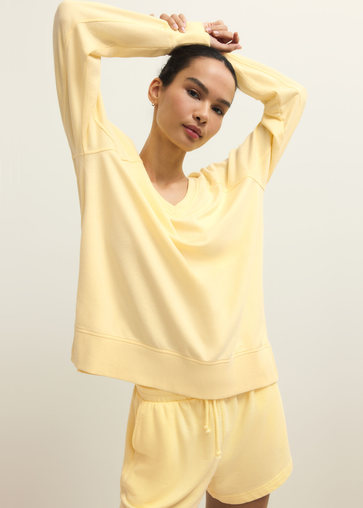 Woman wearing a yellow v-neck sweatshirt with yellow shorts