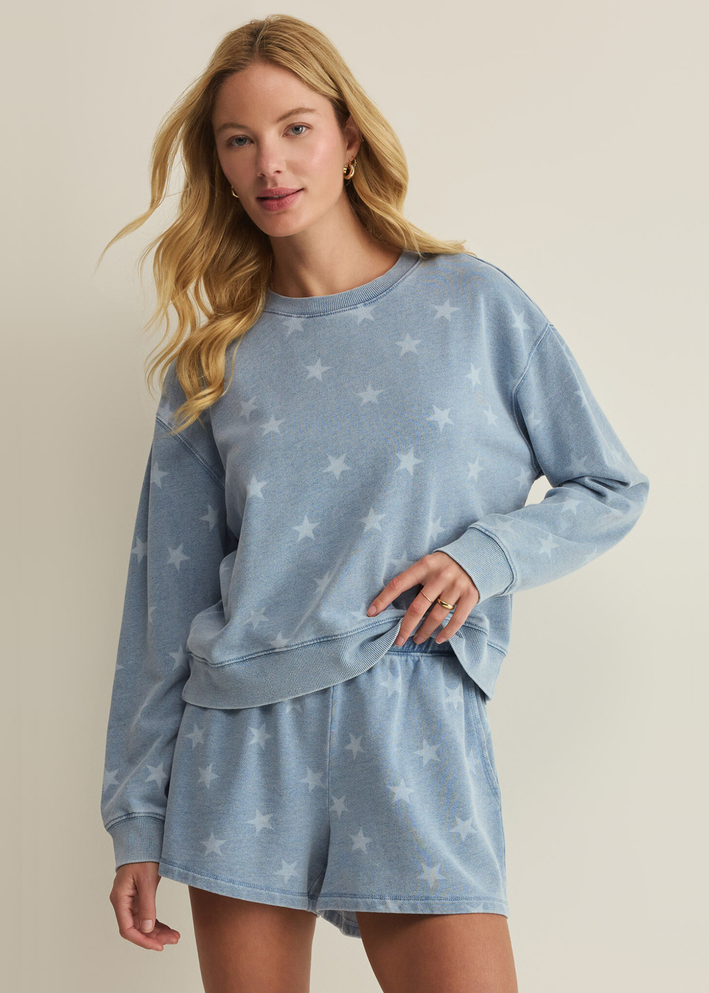 Woman wearing a blue sweatshirt with white stars and matching shorts