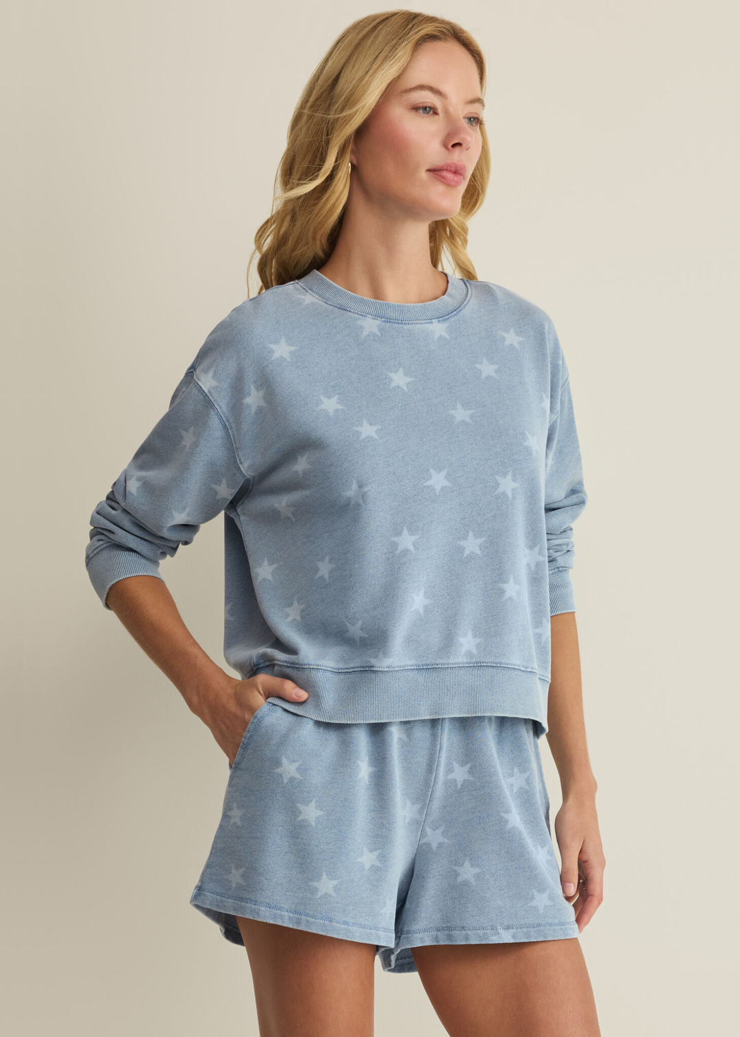Woman wearing a blue sweatshirt with white stars and matching shorts
