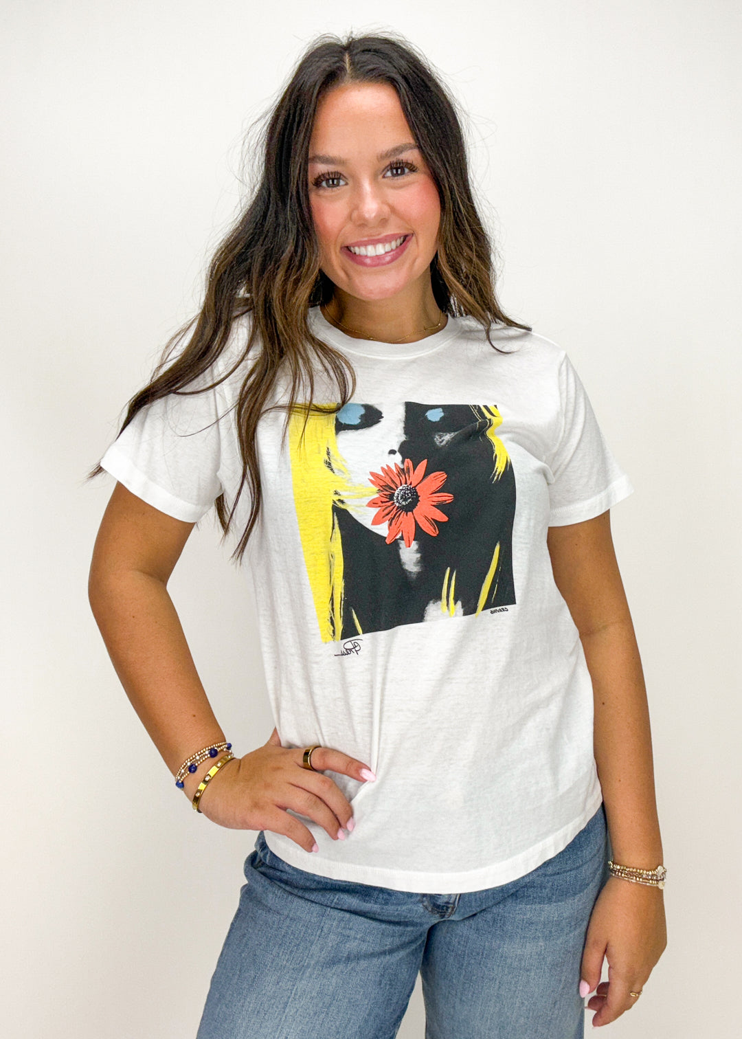 Woman wearing a white t-shirt with a colorful graphic design 
