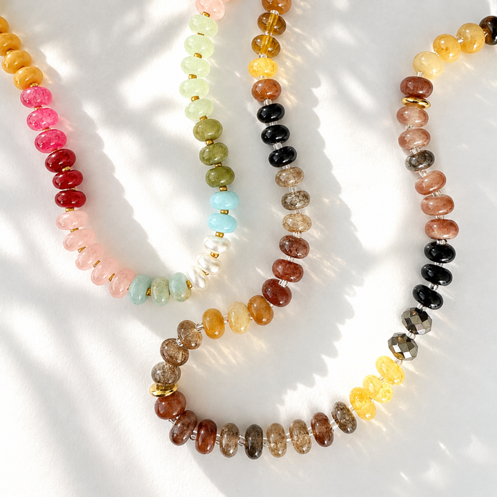 Three beaded necklaces with multicolored beads on a white surface