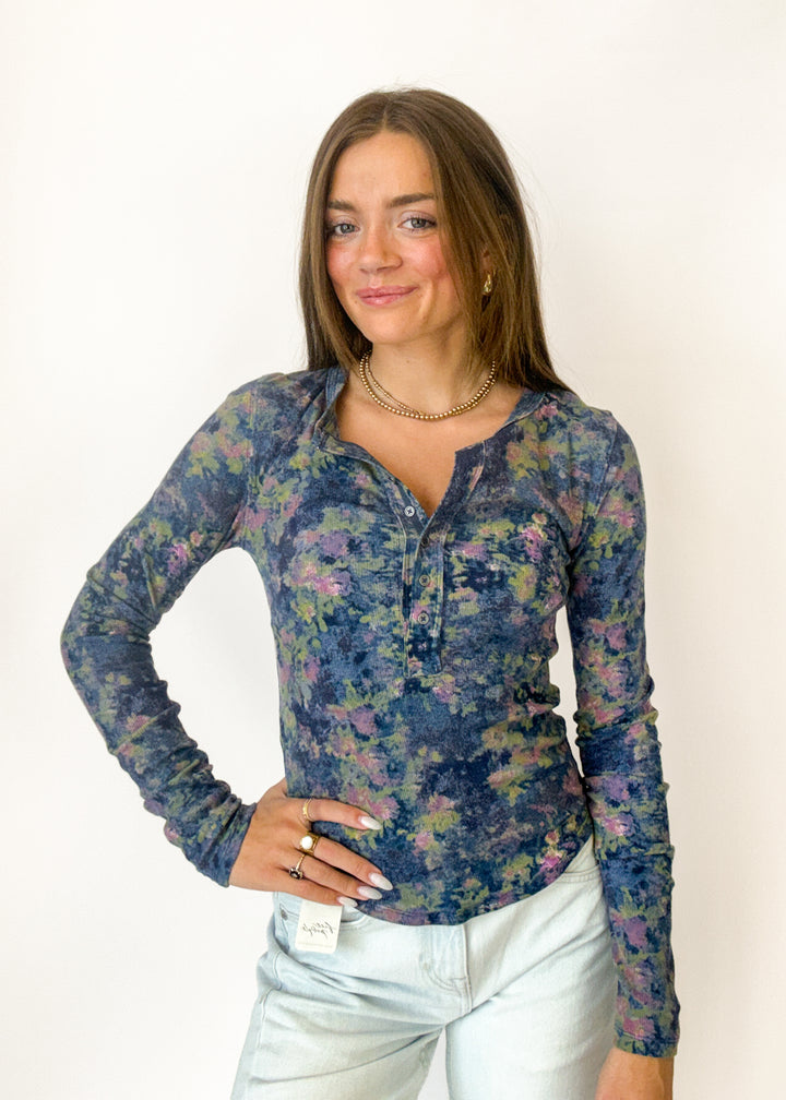 Woman wearing a blue floral henley long sleeve top