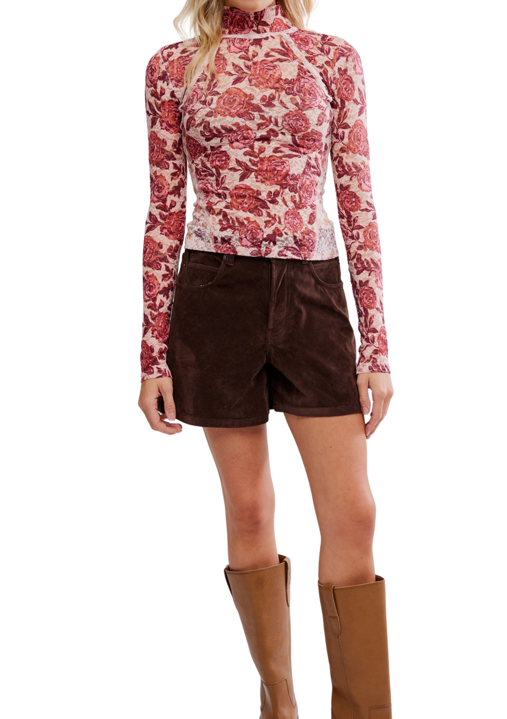 Person wearing a red floral long-sleeve top and brown shorts with brown boots