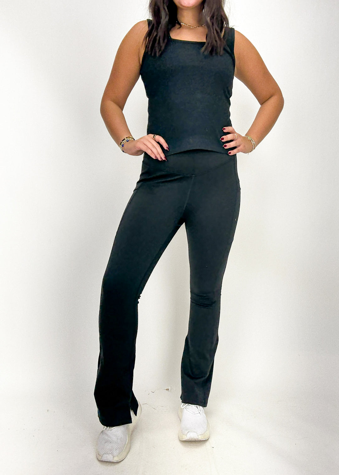 Person wearing a black sleeveless top and black pants