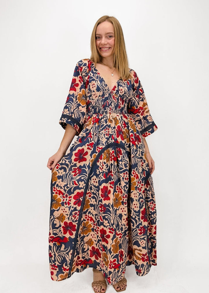 woman wearing indigo, rust, and burgundy floral maxi dress