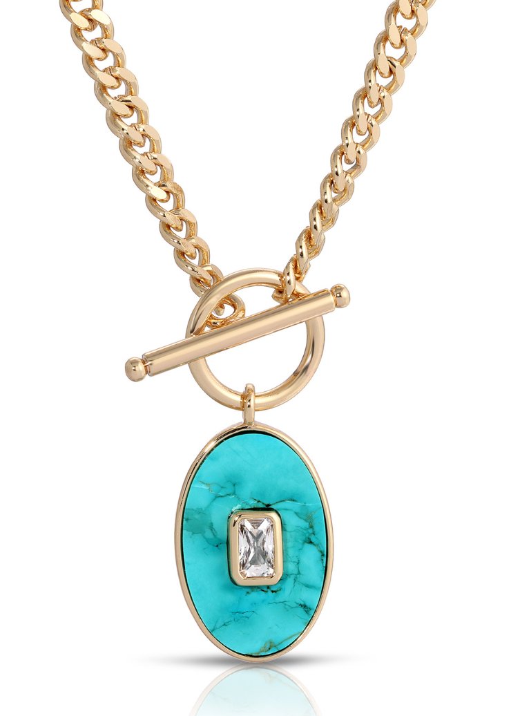 A stylish gold chain necklace featuring a turquoise oval pendant with a sparkling rectangular crystal center from Leeada's Juno collection.