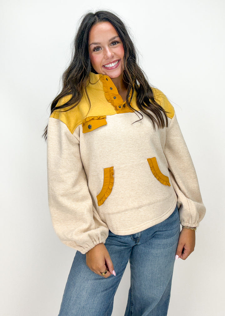 Woman wearing a cream and yellow sweater 