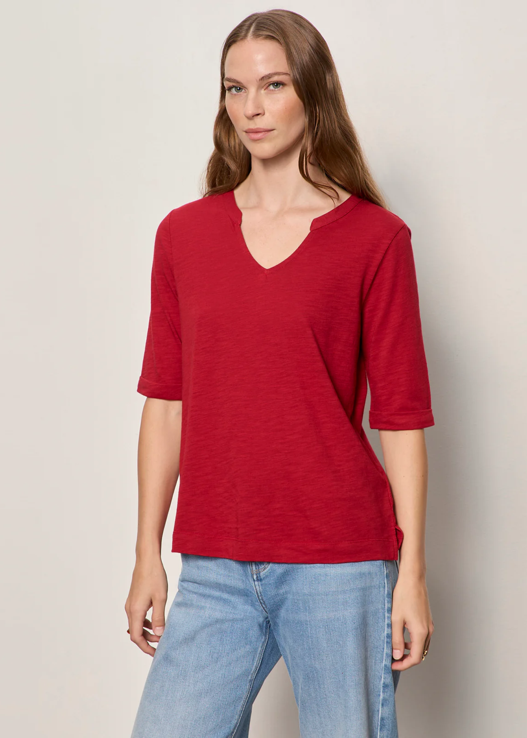 Woman wearing red top with notch neck.