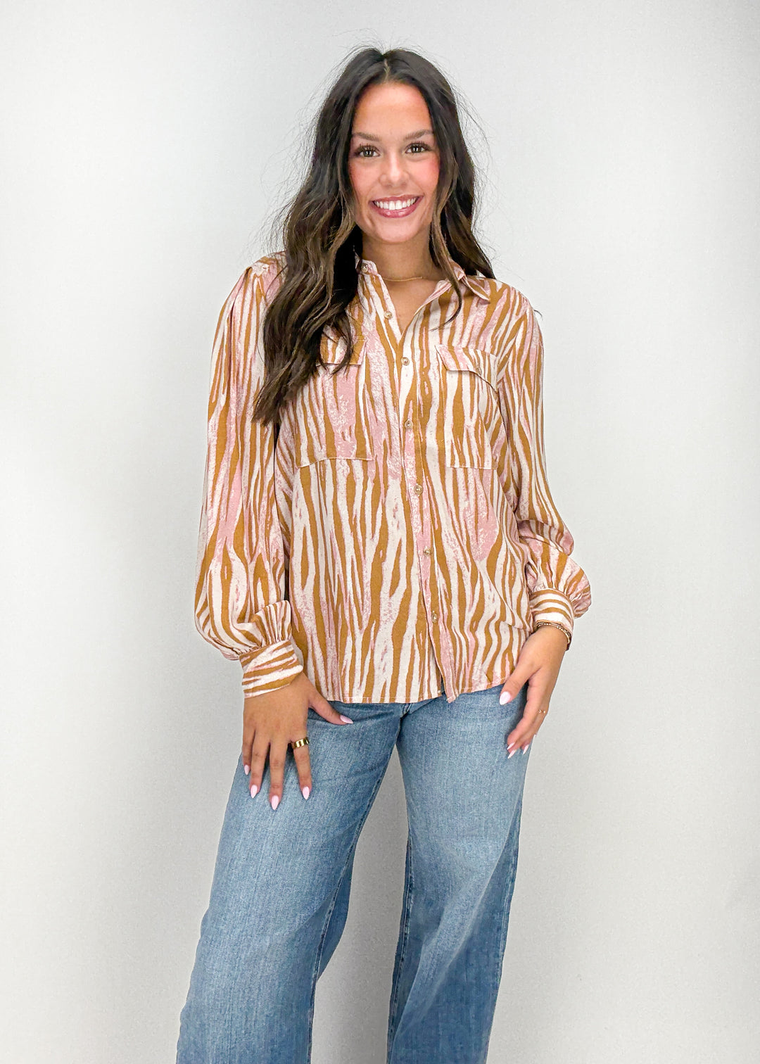 Woman wearing a patterned blouse and jeans 