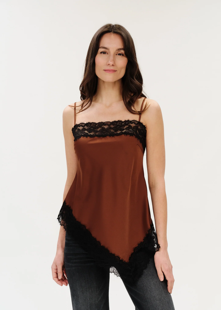 Woman wearing a spaghetti strap tank that is brown with black lace trim.