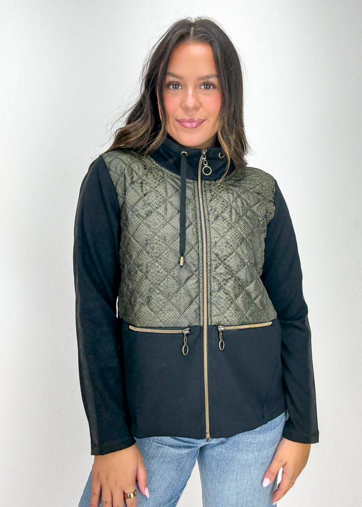 Woman wearing a black and green quilted jacket 
