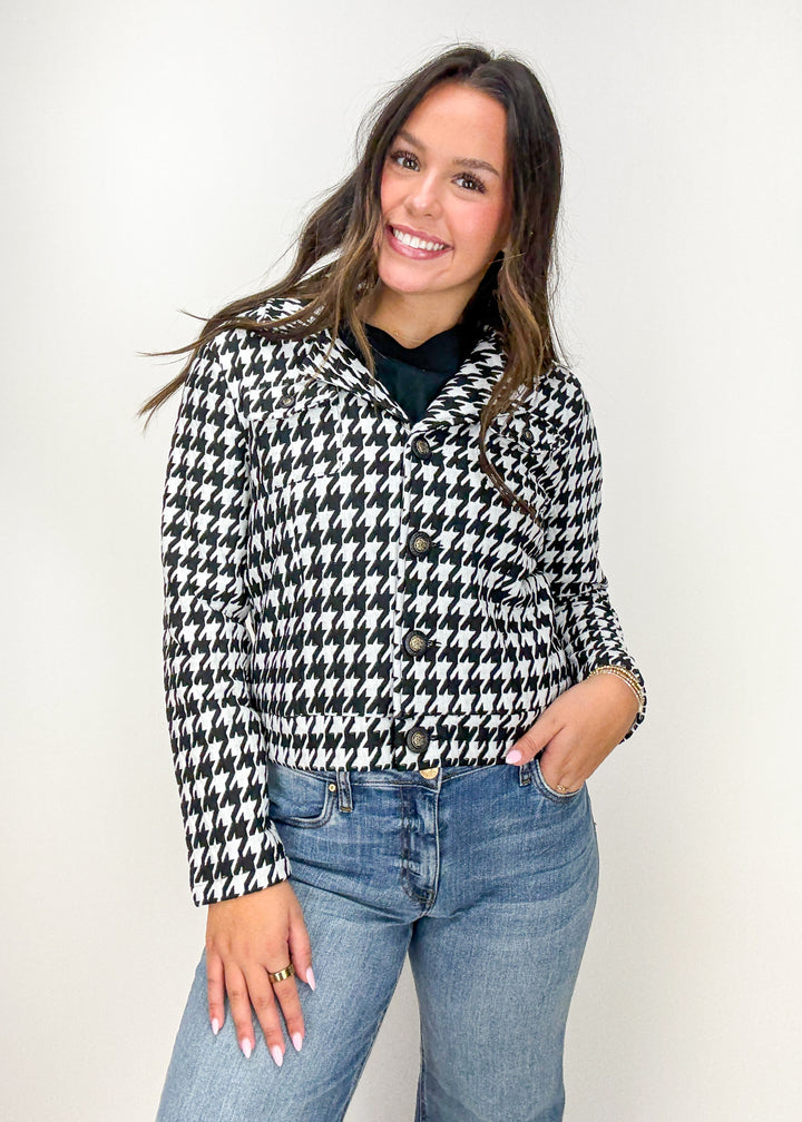 Woman wearing a black and white houndstooth jacket with blue jeans